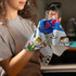 A colourful tea towel featuring playful illustrations, held by a person in an apron, with a glass in hand.