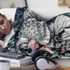 A decorative blanket featuring vibrant floral patterns in various colours, draped over a person lounging on a couch.