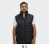 A man wears a black puffer vest with a high collar and two front zip pockets. The vest features a logo.