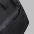 A black duffle bag featuring a patterned inner lining and adjustable straps. It has one visible pocket.