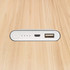 A white power bank with a USB port, a micro USB port, and indicator lights, viewed from the top.