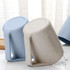 A reusable coffee cup set in light blue and beige, featuring a handle and a textured surface. Contains a logo.