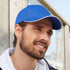 A blue six-panel heavy acrylic sandwich cap with a contrasting white trim, featuring a logo.