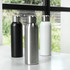 A drink bottle set featuring a black, a silver stainless steel, and a white bottle with metal caps. Each has branding.