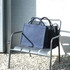 Navy blue recycled tote bags are displayed on a metal chair against a light brick wall. One bag is slightly behind the other.