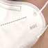 A close-up of a white N95 respirator face mask, featuring a branded logo and a textured surface.