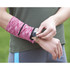 A pink heathered wristband with a pocket, being worn on a person's wrist, featuring a logo.