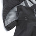 A softshell jacket featuring a black exterior and a patterned grey interior, with visible snaps and a hood.