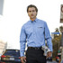 A light blue long sleeve button-up shirt for men, featuring a chest pocket and a logo.