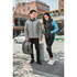 A pair of models wearing a grey puffer jacket and a black insulated vest, set in an urban environment.