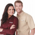 A women's long sleeve button-up shirt in burgundy, displayed by a woman, alongside a man in a tan shirt, both featuring logos.
