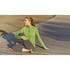 A woman sits on a wooden surface wearing a green Taza Knit Quarter Zip jumper and grey leggings. The jumper has a logo.