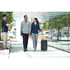 A woman in a navy knit half-zip jumper and grey pants walks with a man in a light grey knit half-zip jumper.