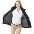 A woman wearing a black fleece lined jacket, smiling and showcasing the interior, with a collared white shirt underneath.