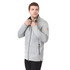 A grey men's softshell jacket featuring a zip front and zippered pockets, worn by a model with a logo on the sleeve.