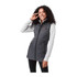 A woman wearing a grey insulated puffer vest over a light grey long-sleeve top, smiling while posing.