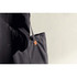 A dark grey tote bag with a branding tag, held by a person in black clothing against a neutral background.