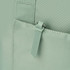 A mint green tote bag featuring a zippered pocket and textured fabric, with a logo on the zipper tag.
