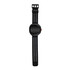 A black smart watch with a round face and a perforated strap, featuring an orange button on the side.