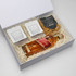 A gift box containing a bottle of whisky, pretzels, and two takeout-style containers. Predominantly brown and white.