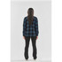 A woman's long-sleeve button-up shirt in navy and black plaid, viewed from the back, worn with black pants.