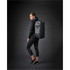 A woman in athletic wear stands sideways, carrying a grey Equinox 30 duffel bag with a logo.