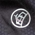A close-up of a textured fabric in black with a circular logo pattern.