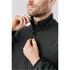 A men's full zip jacket in dark grey, being zipped up by a man. Features a collar and a logo.