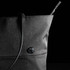 A black tote bag with a structured design and a sleek shoulder strap, featuring a circular logo.