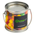 A small clear PVC bucket filled with vibrant Skittles in various colours, featuring a metal handle and a logo.