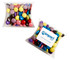 A pillow pack containing a variety of colourful choc beans in purple, yellow, green, red, and blue. It has a branding logo.