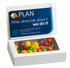 A white box containing colourful Skittles candies, featuring a branding logo on the lid.