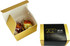 A gold and white box containing two chocolate balls, featuring branding on the exterior.