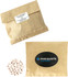 A kraft paper bag containing white mints, accompanied by another bag with a logo.