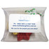 A clear pillow pack containing Christmas-themed chocolates wrapped in red, gold, and silver foil.