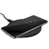 A wireless charger with a smartphone placed on top, displaying a charging indicator on the screen.