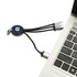 A round-shaped light-up charging cable in black with multiple connectors, plugged into a laptop's USB port.