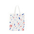 A cotton bag features a white background with colourful abstract shapes in red and blue, and short handles.