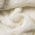 A soft, cream-coloured wearable blanket made from 100% polyester with a plush, textured surface and folds.