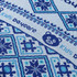 A close-up of a patterned fabric in shades of blue featuring geometric designs and a bear logo.