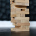 A wooden block tower made of light-coloured timber blocks, stacked in a stable formation against a blurred background.