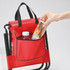 A red children's foldable camping chair with a bag featuring a pocket, perfect for storing a drink bottle and snacks.