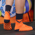 Orange and navy football socks featuring a towel bottom and a patterned grip sole, with a logo visible.