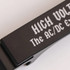 A black aluminium keyring bottle opener featuring a logo.