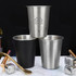 A drink bottle set featuring three stainless steel cups in silver and black, with a logo on one cup.