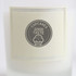A 2.2oz glass candle featuring a cream-coloured label with a logo and text related to cupcakes and good taste.