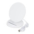 A round white wireless charging stand with a USB cable attached. It has a sleek, minimalist design.