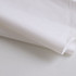 A white biodegradable mailer bag with a smooth texture, slightly crumpled and folded on a light surface.