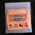 An eco-friendly biodegradable self-adhesive bag in a transparent plastic packaging, featuring an orange bag inside.