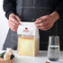 A transparent sealing storage bag holding a loaf of bread, featuring a logo and a white top closure.